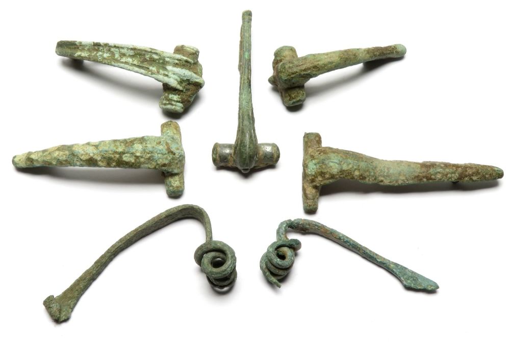 Lot 1041: Iron age and Roman brooch group. Seven brooches...
