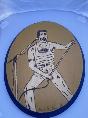 Pyrography Wood Plaque Depicting Freddie Mercury, Signed Jason M. Smith '13. A single wooden 