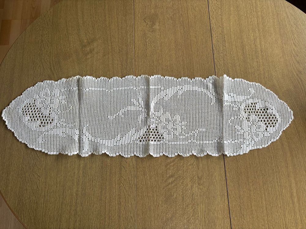 Lace Center Table. Handmade oval-shaped lace centerpiece with floral design. Signs of use.