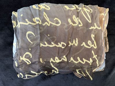 Len&ccedil;o em poli&eacute;ster com padr&atilde;o letras. Sinais de uso.