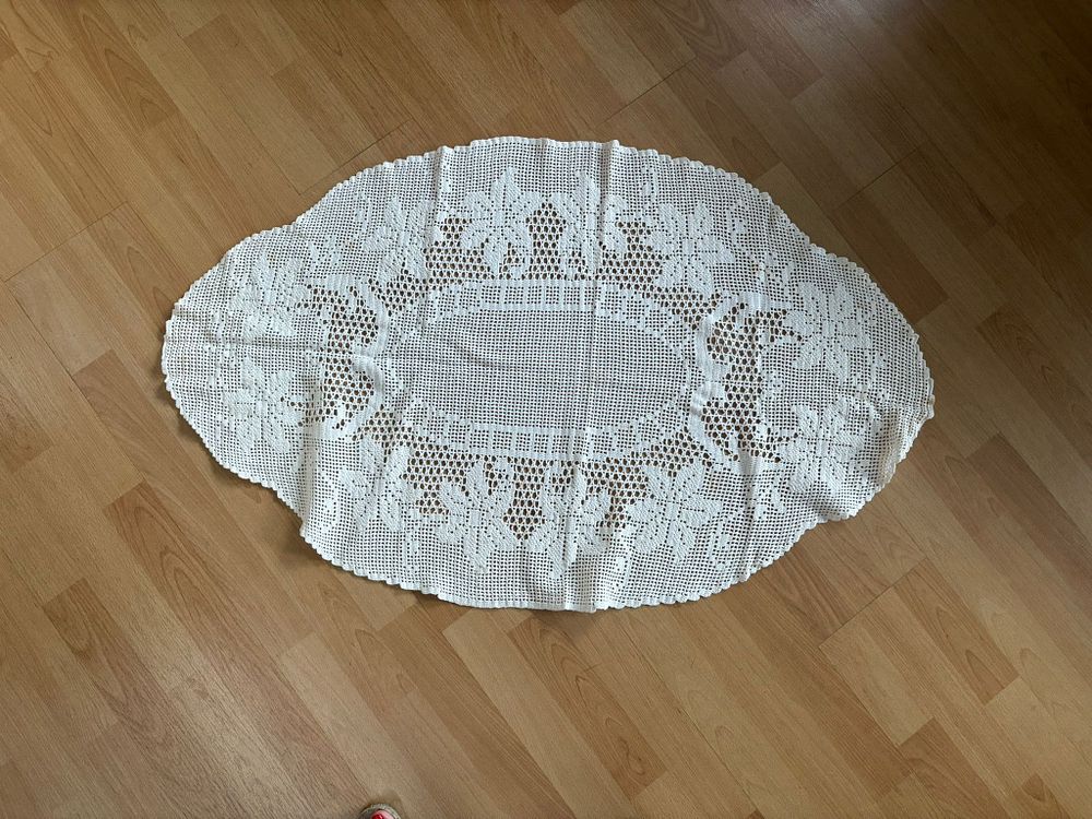 Lace Center Piece. Oval-shaped lace centerpiece with floral design. Signs of use.