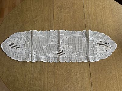 Lace Center Table. Handmade oval-shaped lace centerpiece with floral design. Signs of use.