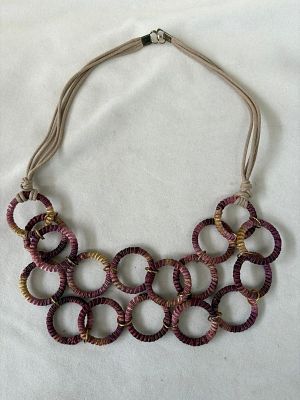 Colar com c&iacute;rculos forrados a tecido e detalhes em dourado. Sinais de uso.