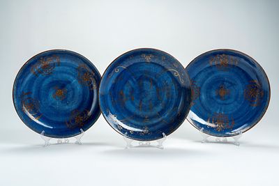Tre piatti in porcellana con invetriatura powder blue e decori dorati. Cina, secolo XVIII/XIX d 