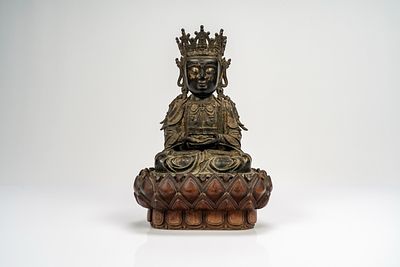 Guanyin in bronzo cesellato, con tracce di doratura, su base lignea a fiori di loto di epoca 
