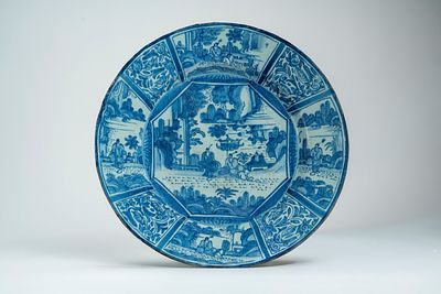 Piatto in maiolica bianca e blu decorato con figure entro riserve. Delft, secolo XVIII d cm 39