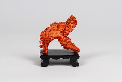 Scultura in corallo rosa intagliato raffigurante scena allegorica con putto alato dormiente e 