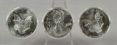 TRIO OF SILVER EAGLE ART ROUNDS. EACH ONE OUNCE FINE SILVER, IN ACRYLIC CASE