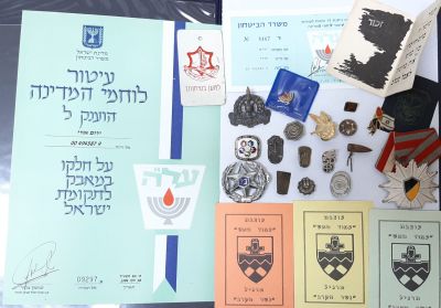 לוט סמלים ותעודות שונות. בין הפריטים תעודת עיטור שניתה לאורי ירום. אורי ירום (8 במאי 1931[1] – 8 