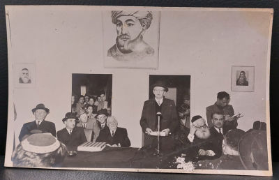 הנשיא יצחק בן צבי - תצלום מיוחד בו נראה נואם בכנס, מעליו מתנוססת תמונת הרמב"ם סביב השולחן רבנים 