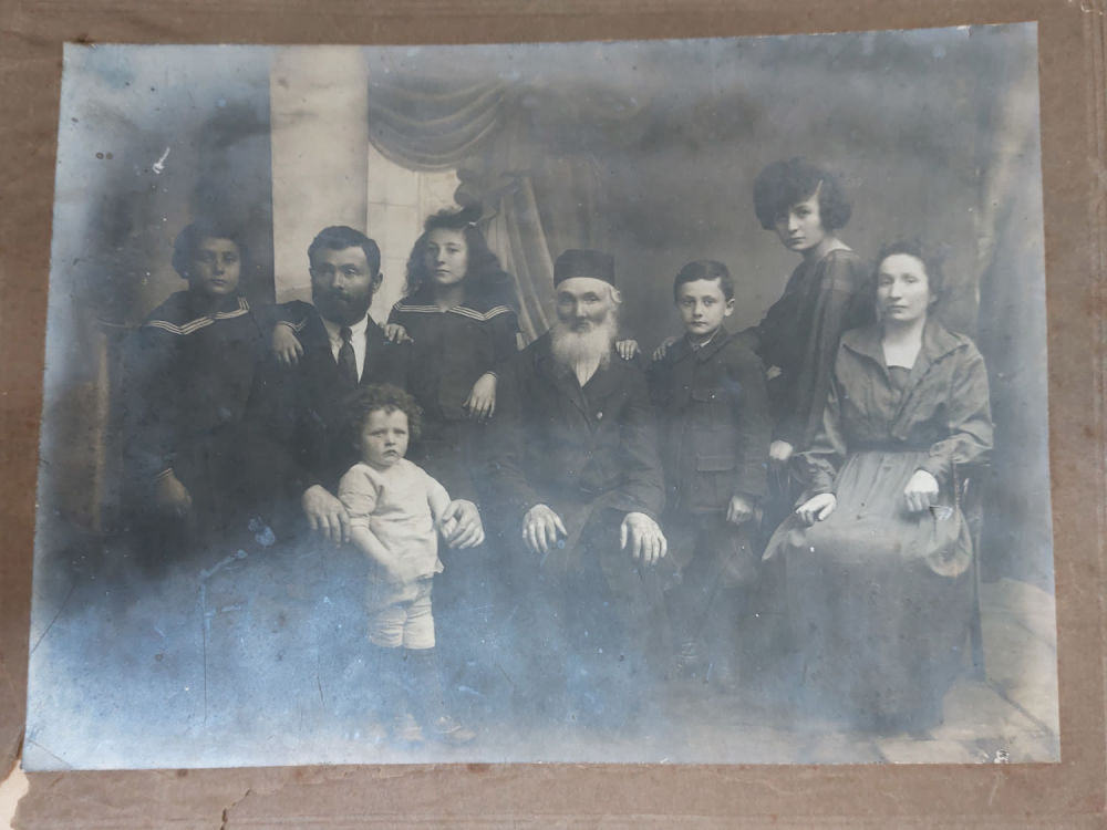 צילום גדול ישן של משפחה יהודית ובמרכזה יהודי נשוא פנים. מתוארך מאחור 1922