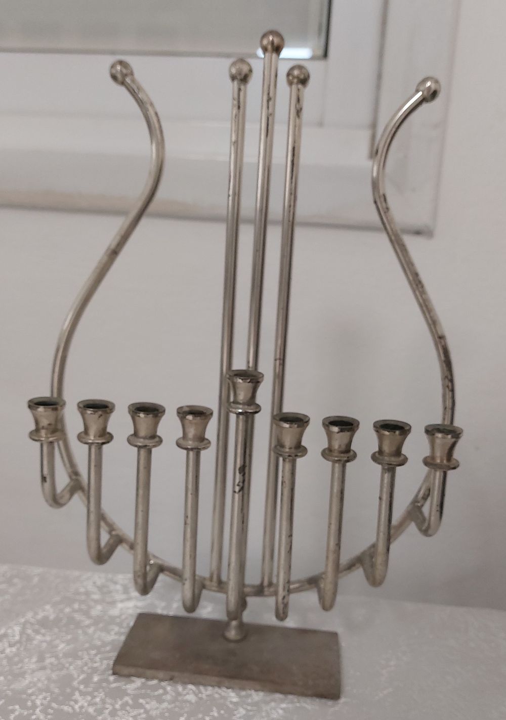 חנוכיה עשויה מתכת בצורת כינור. 
גובה: 28 ס"מ