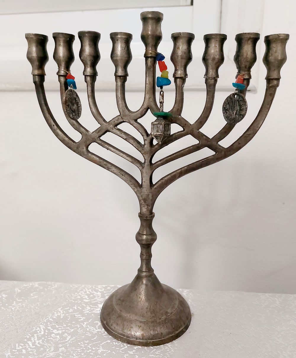 חנוכיה מיוחדת תלוי עליה סביבון וכן מטבעות בסגנון עתיק.
גובה:25 ס"מ, אורך: 19 ס"מ