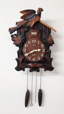 שעון קוקייה וינטג' בינוני עם גוף עץ ומנגנון מכני. גובה 36 ס"מ. רוחב 26 ס"מ. עומק 12 ס"מ. 
מצב 