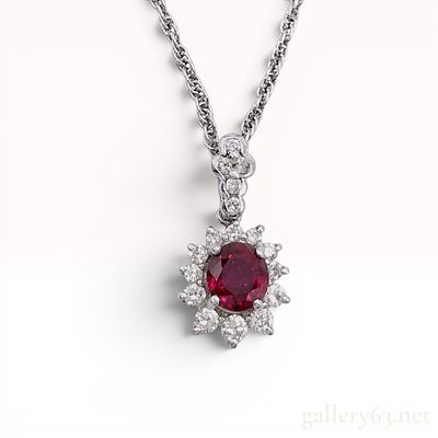 Platinum Ruby and Diamond Halo Pendant Necklace. A gemstone pendant necklace featuring a central 