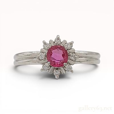 Platinum Pinkish-Red Ruby and Diamond Cluster Ring. A platinum cocktail ring featuring a 