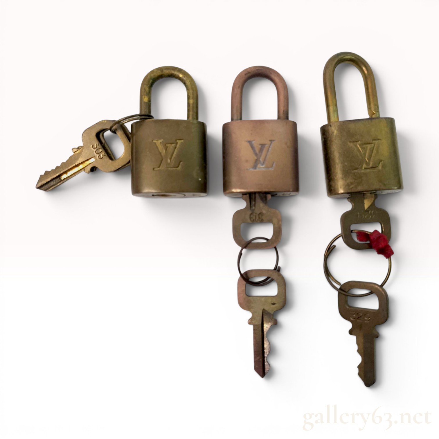 A Trio of Louis Vuitton Brass Padlocks and Keys