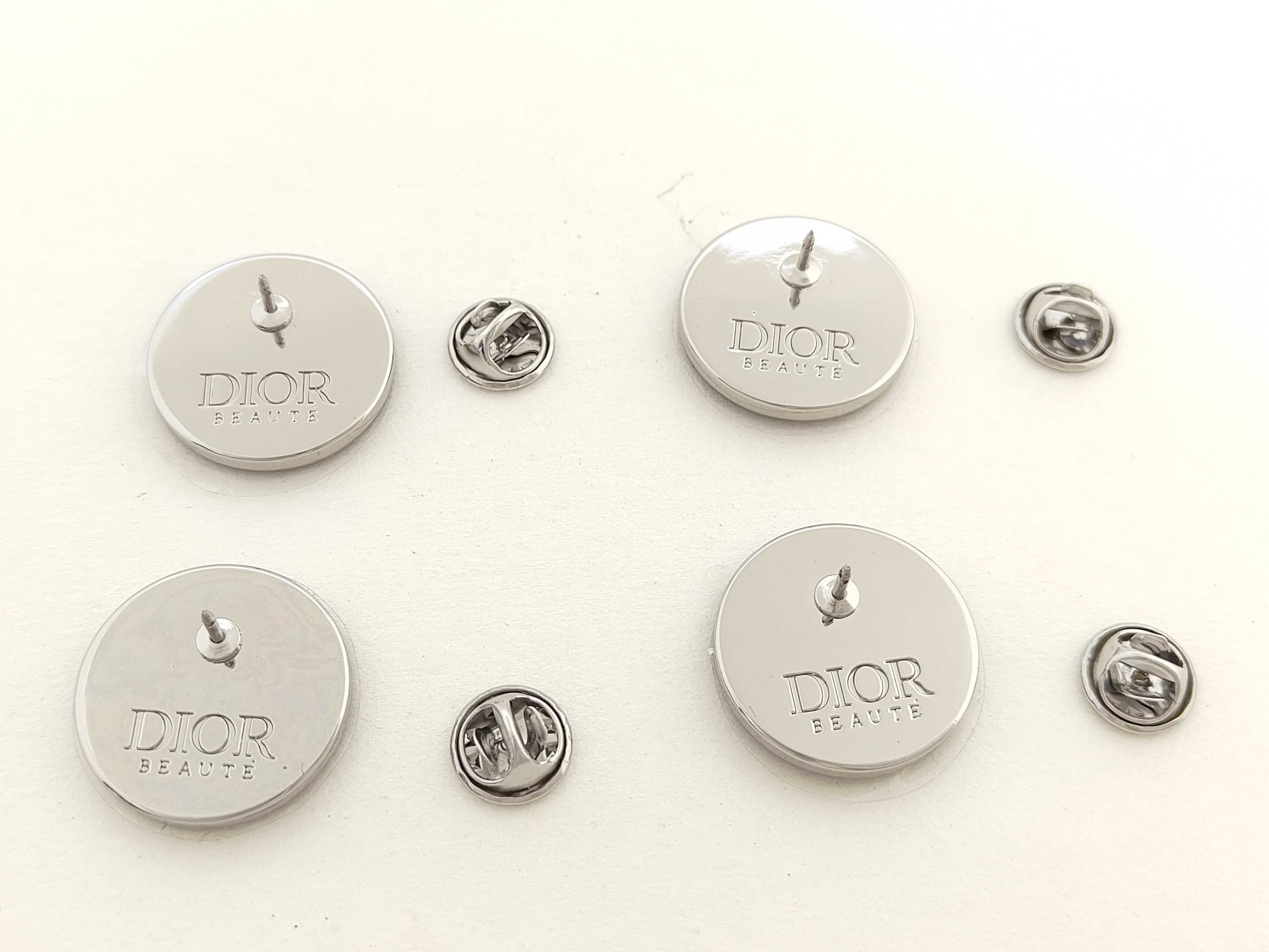 A Set of Four Dior Beaute Novelty Circular Lapel Pins