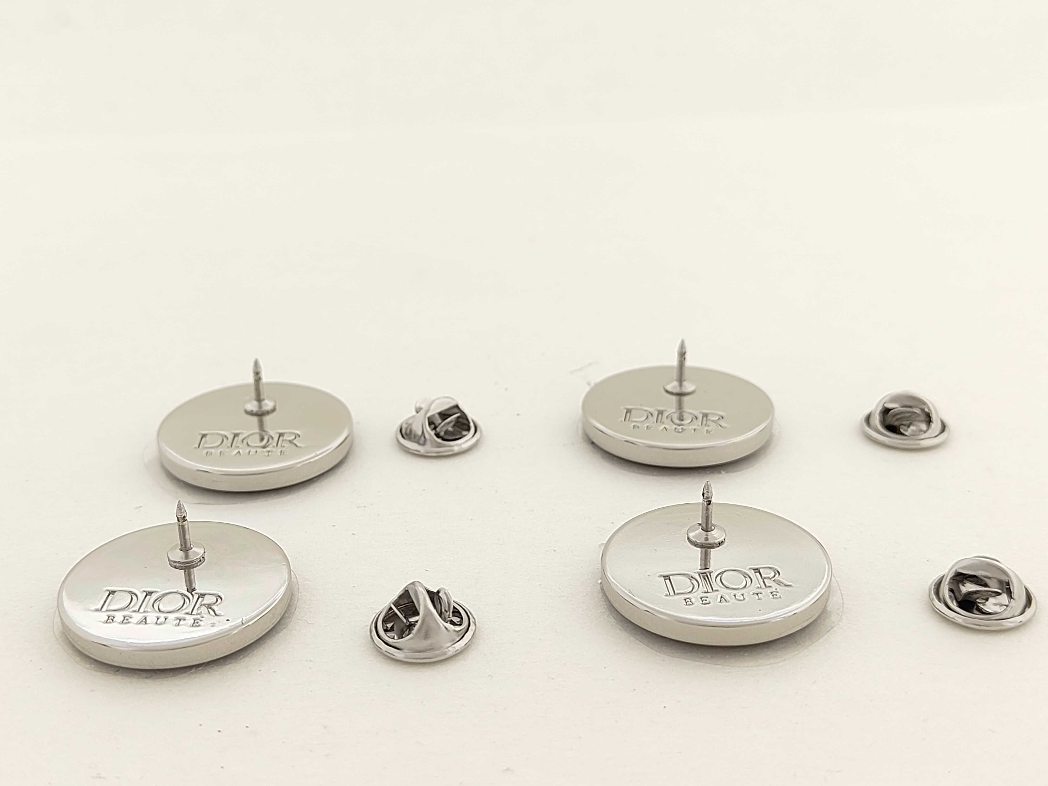 A Set of Four Dior Beaute Novelty Circular Lapel Pins