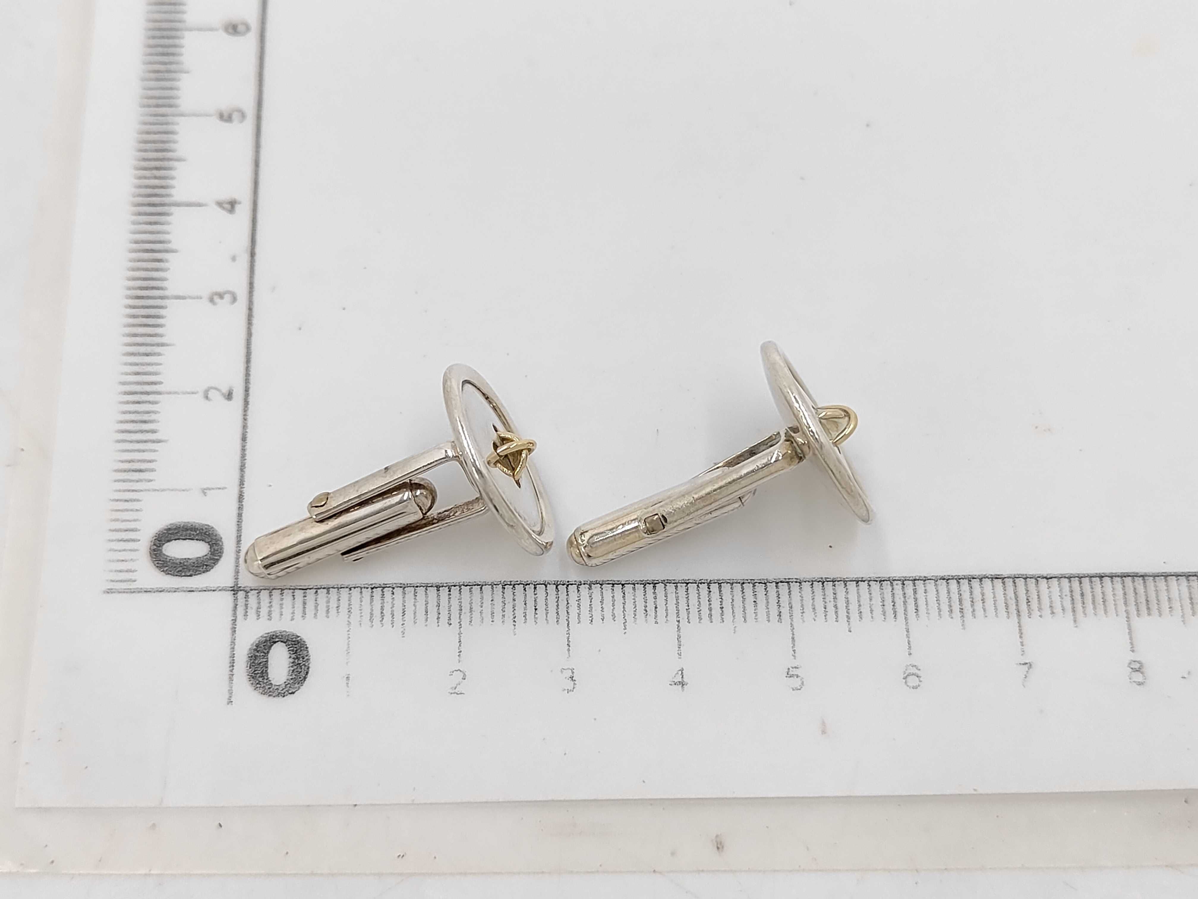 A Pair of Tiffany & Co. Sterling Silver and 18 Karat Yellow Gold Button-Motif Cufflinks