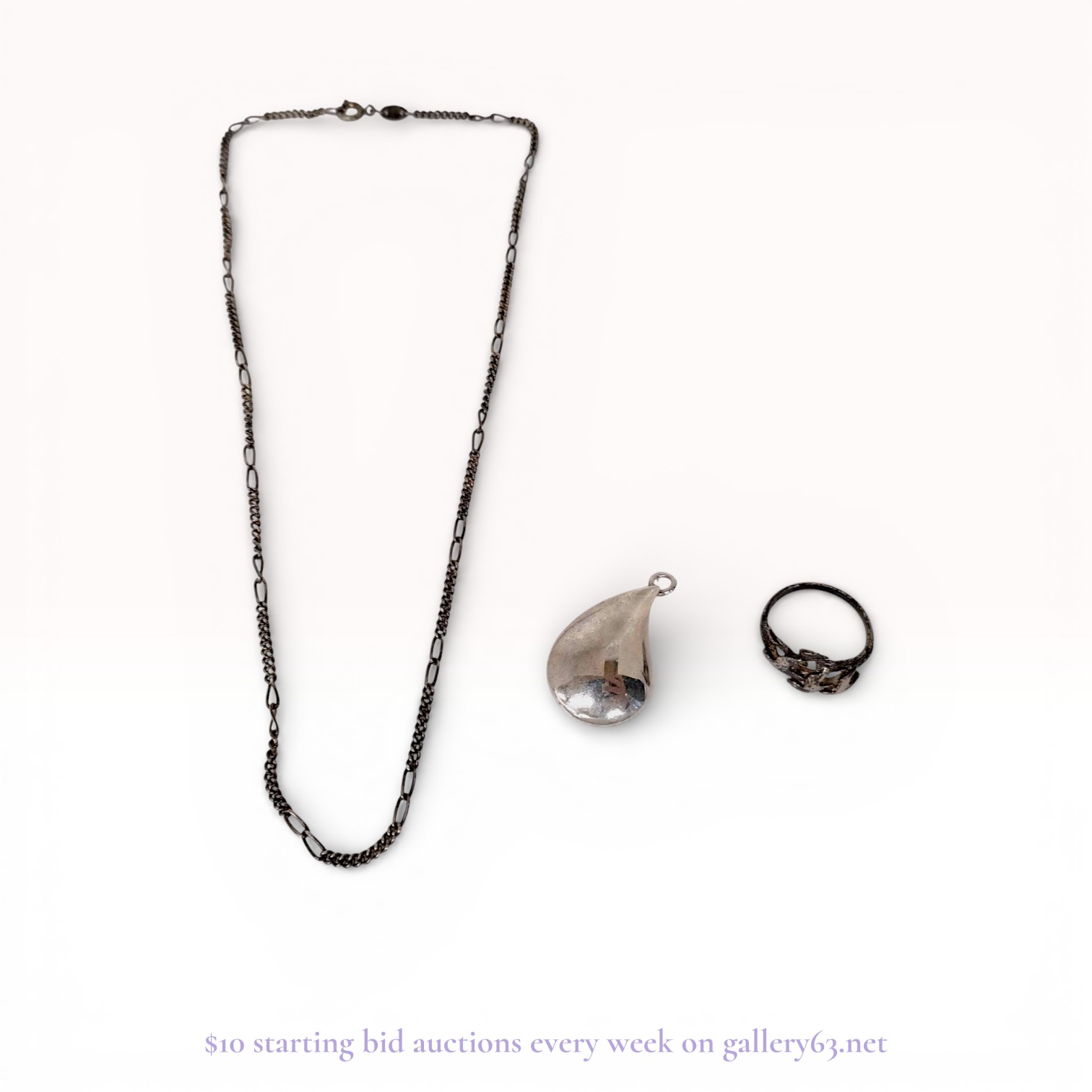 A Trio of Silver and Silver-Tone Jewelry Including a Figaro Chain, Teardrop Pendant, and Figural Bird Ring