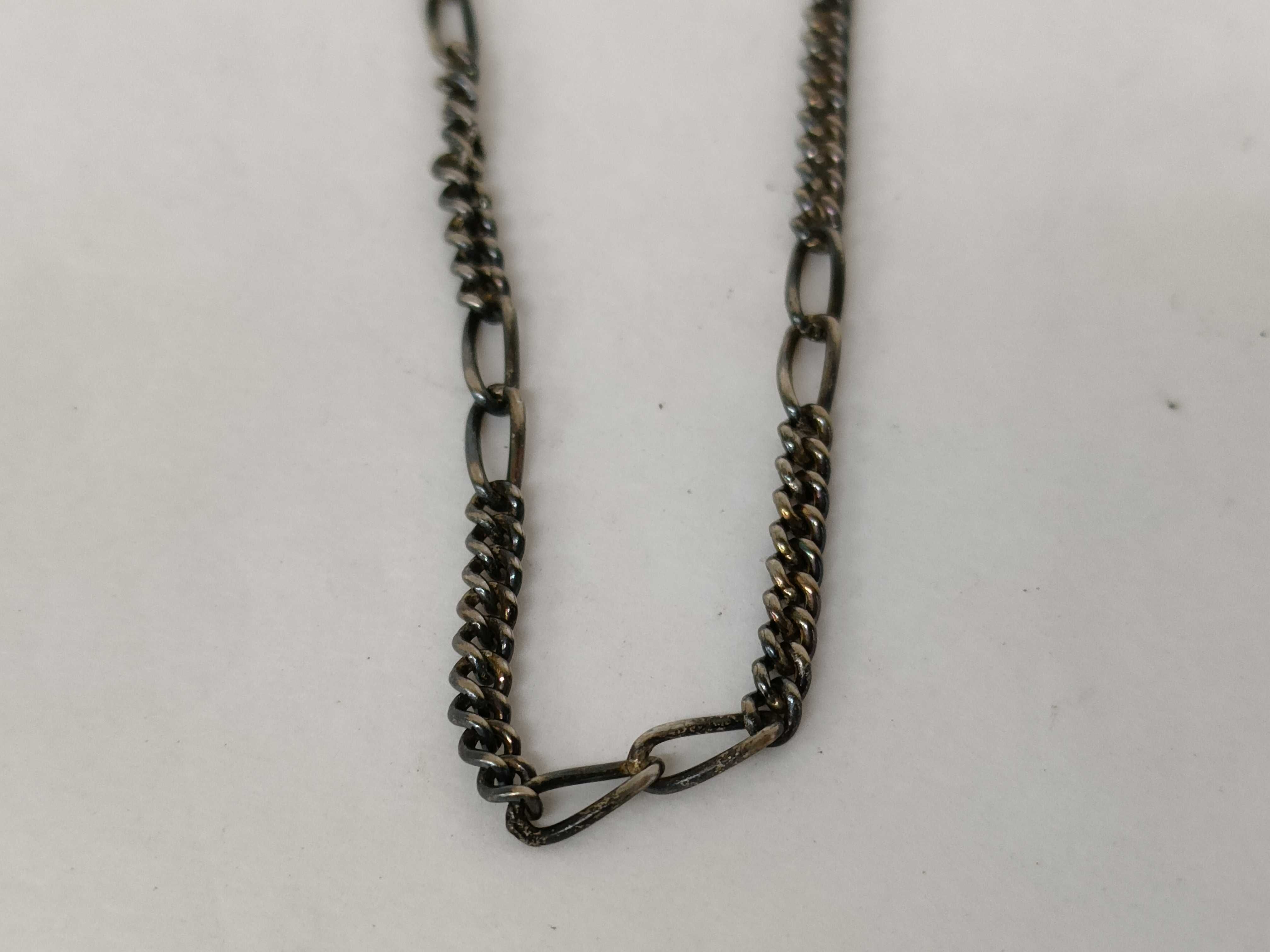 A Trio of Silver and Silver-Tone Jewelry Including a Figaro Chain, Teardrop Pendant, and Figural Bird Ring