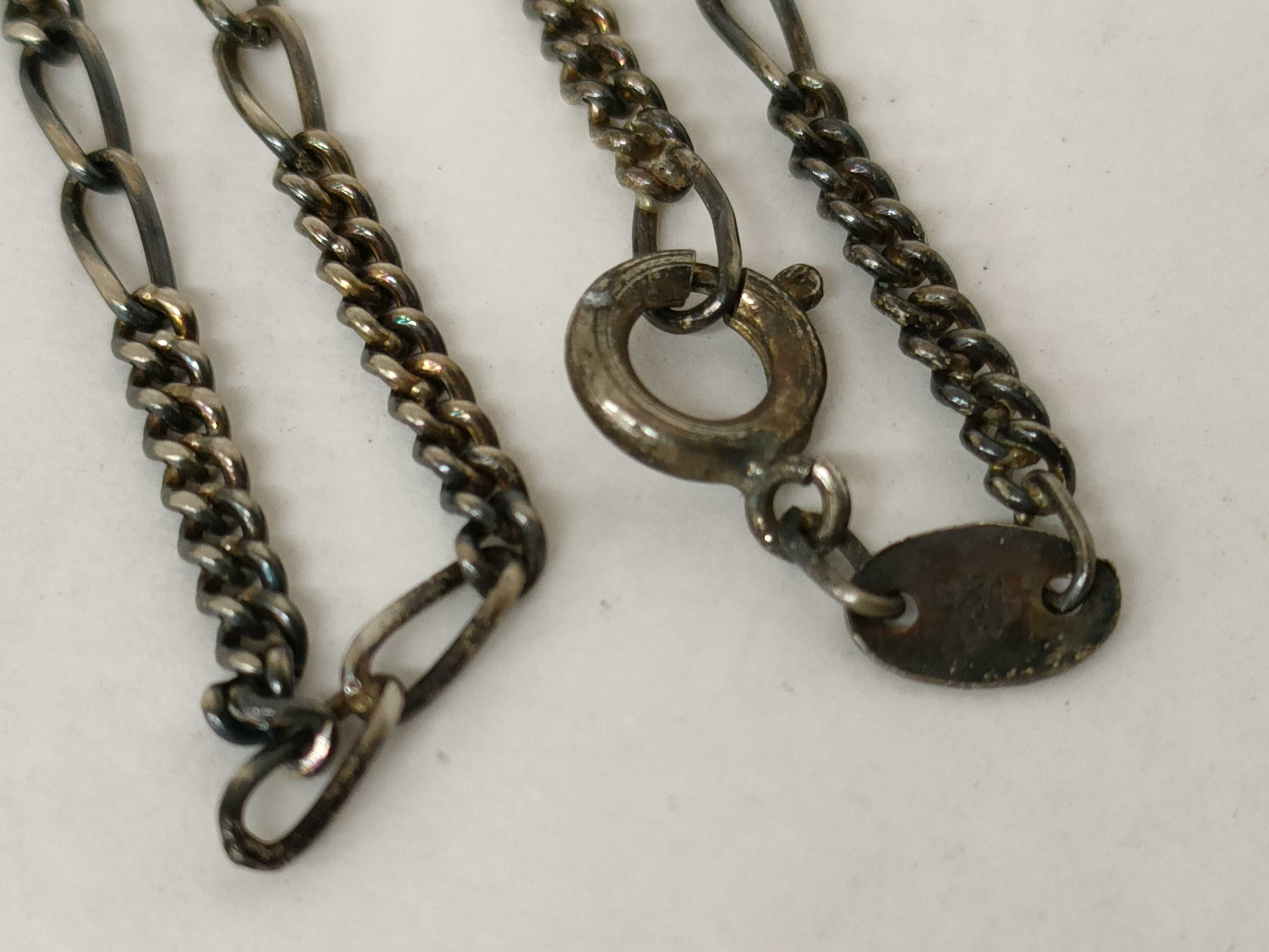 A Trio of Silver and Silver-Tone Jewelry Including a Figaro Chain, Teardrop Pendant, and Figural Bird Ring