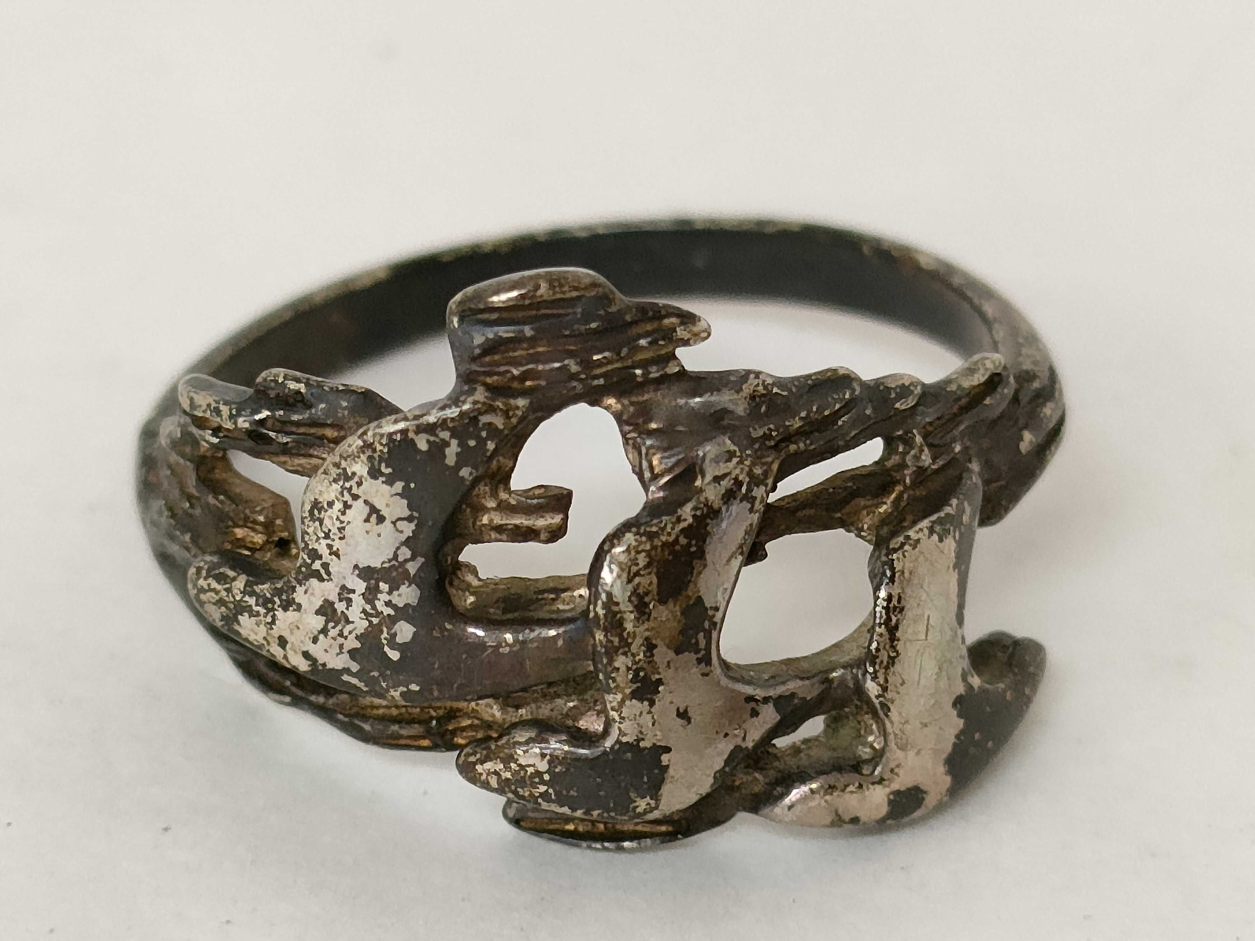A Trio of Silver and Silver-Tone Jewelry Including a Figaro Chain, Teardrop Pendant, and Figural Bird Ring