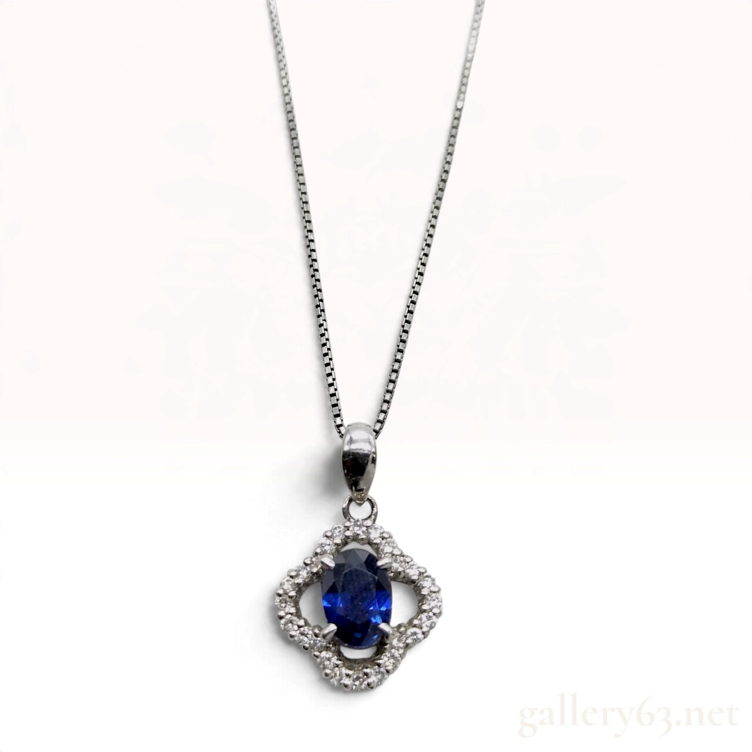 A Platinum Oval Sapphire and Diamond Clover Halo Pendant Necklace