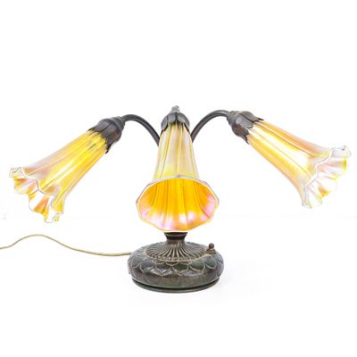 Tiffany Studios New York glass and bronze three light piano table lamp. having three golden 