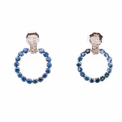 14K WG Sapphire & Diamond Classic Earrings. Deep blue sapphire hoops fall from diamond-sprinkled 