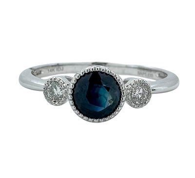 A classic 14K gold ring set with white diamonds and a sapphire gemstone with a strong color and