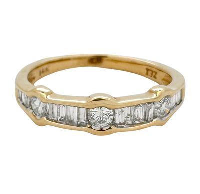 14K yellow gold ring set with a combination of round and tapered baguette diamonds with a total