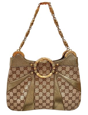 GUCCI 
תיק כתף אותנטי זה של GUCCI עם שרשרת במבוק מונוגרמה בצבע מטאלי הוא תיק יד שיקי עשוי מבד 