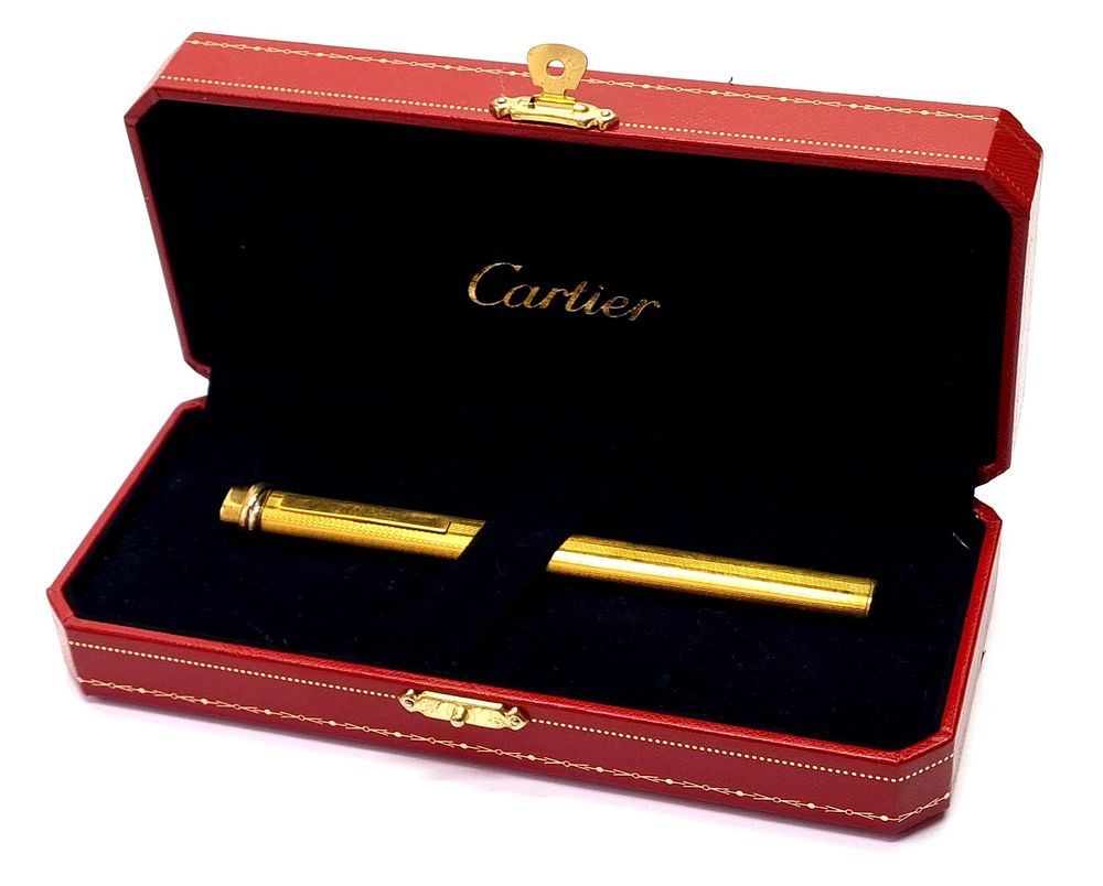 קרטייה - CARTIER
. עט כדורי, וינטג', מפואר מאוד, מצופה זהב. 
נתון במארז מקורי, יפה ואיכותי. זקוק 