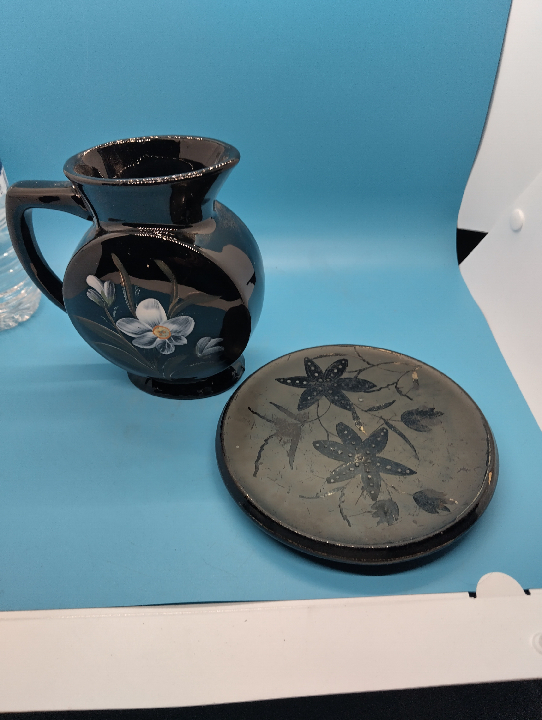 VERY COLLECTIBLE two pieces of Victorian Jet ware Hand-Painted Enamelled Black Tableware including pot stand and jug, Small chip to lip of jug in pic