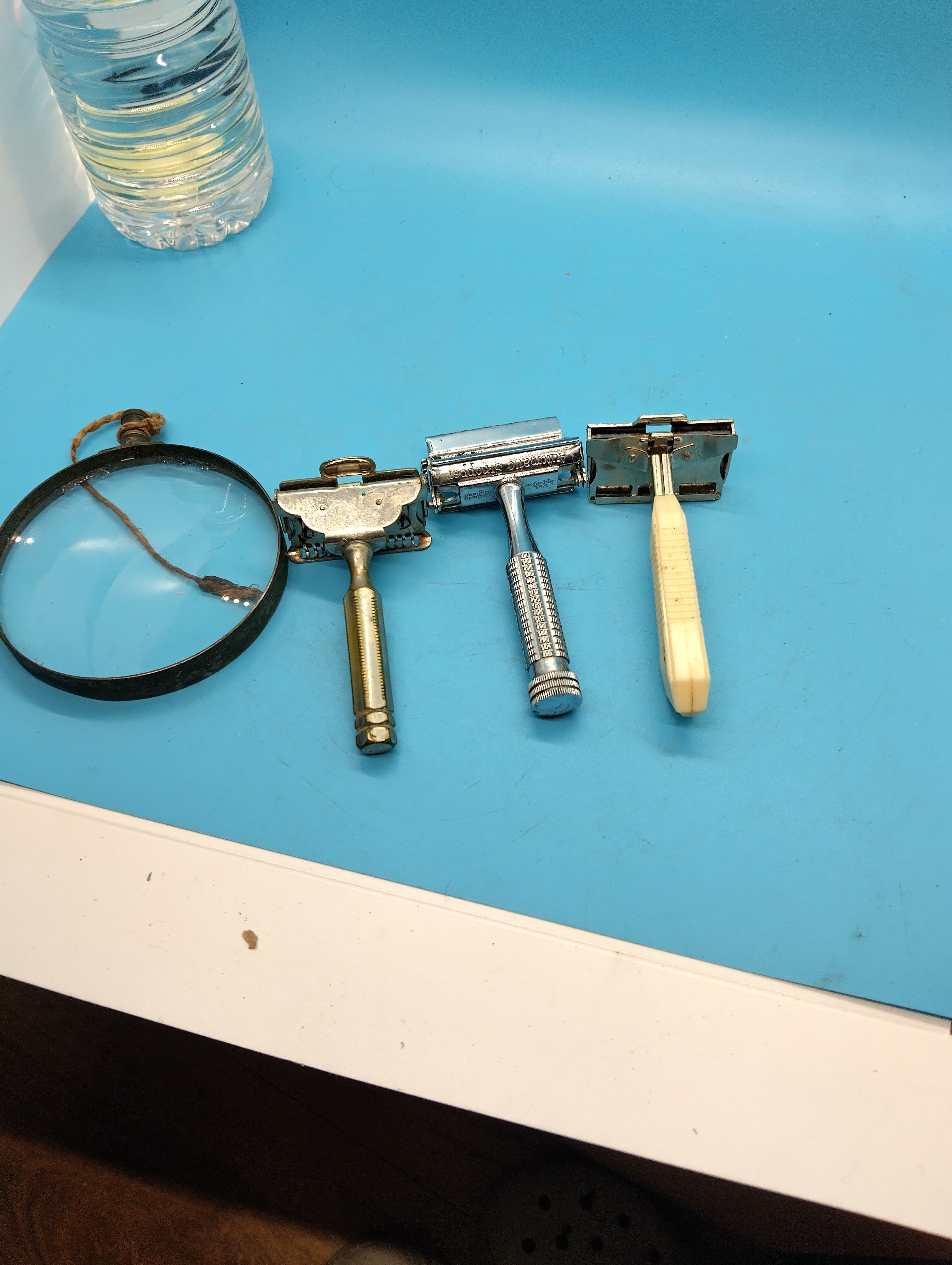 A Group of Vintage Single-Edge Safety Razors and a Magnifying Glass