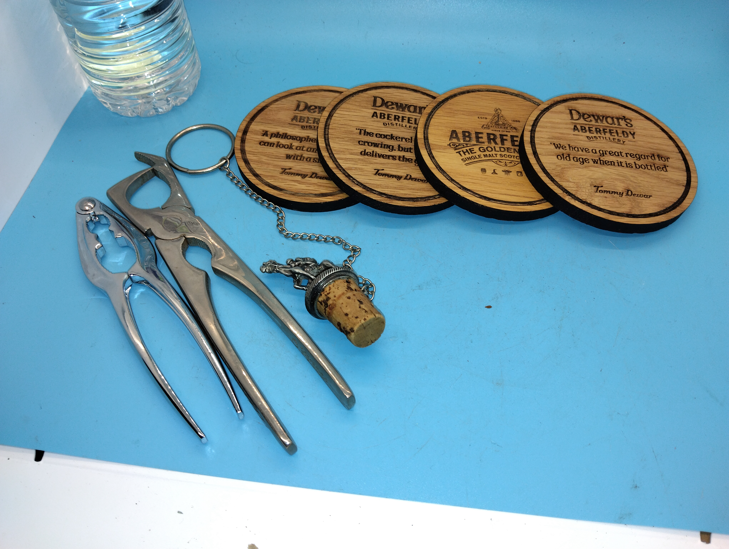 A Collection of Dewar's Aberfeldy Distillery Coasters and Metal Barware Accessories
