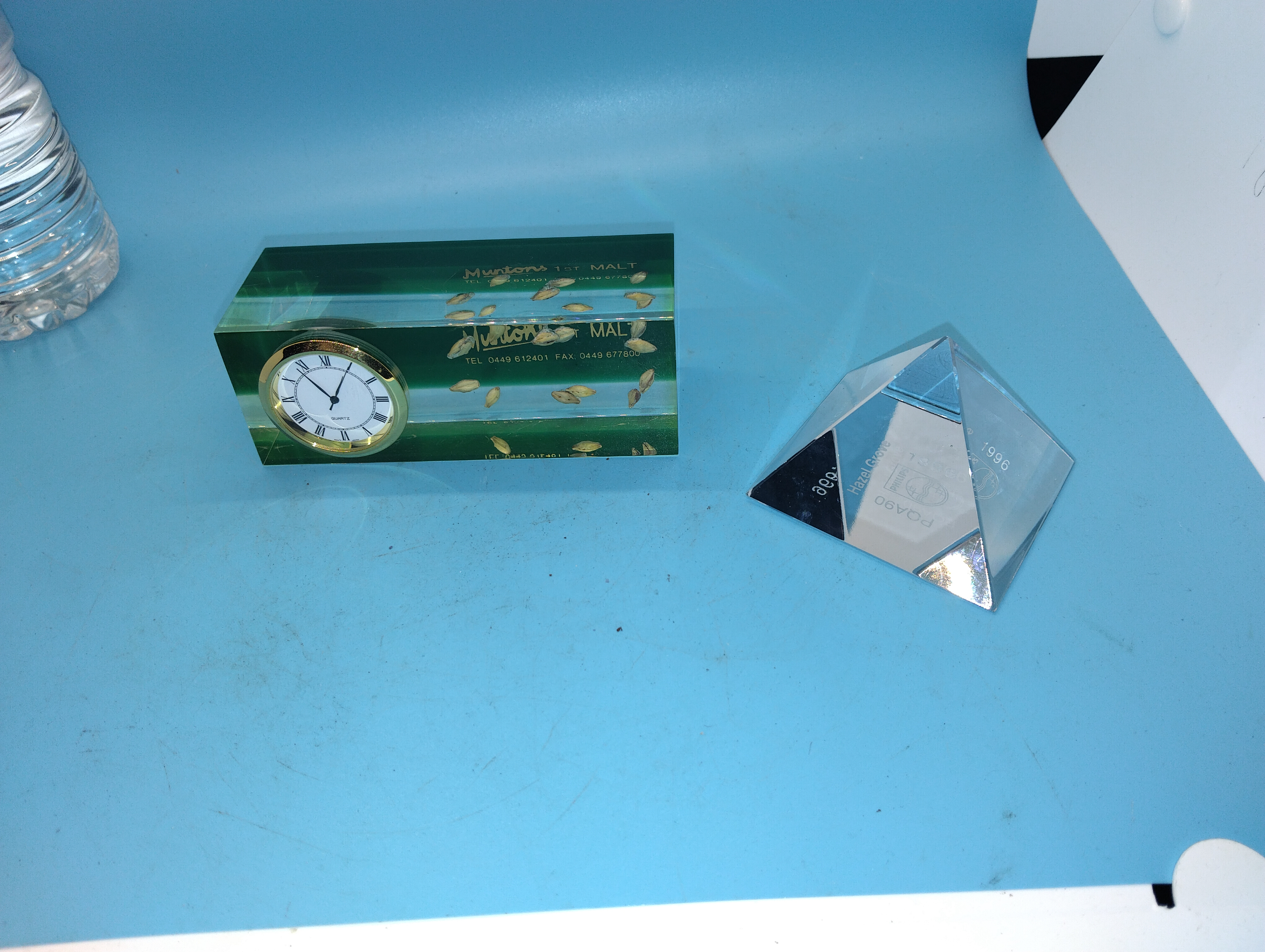 Two Corporate Promotional Desk Items Comprising a Muntons Malt Paperweight Clock and a Philips Glass Pyramid Award