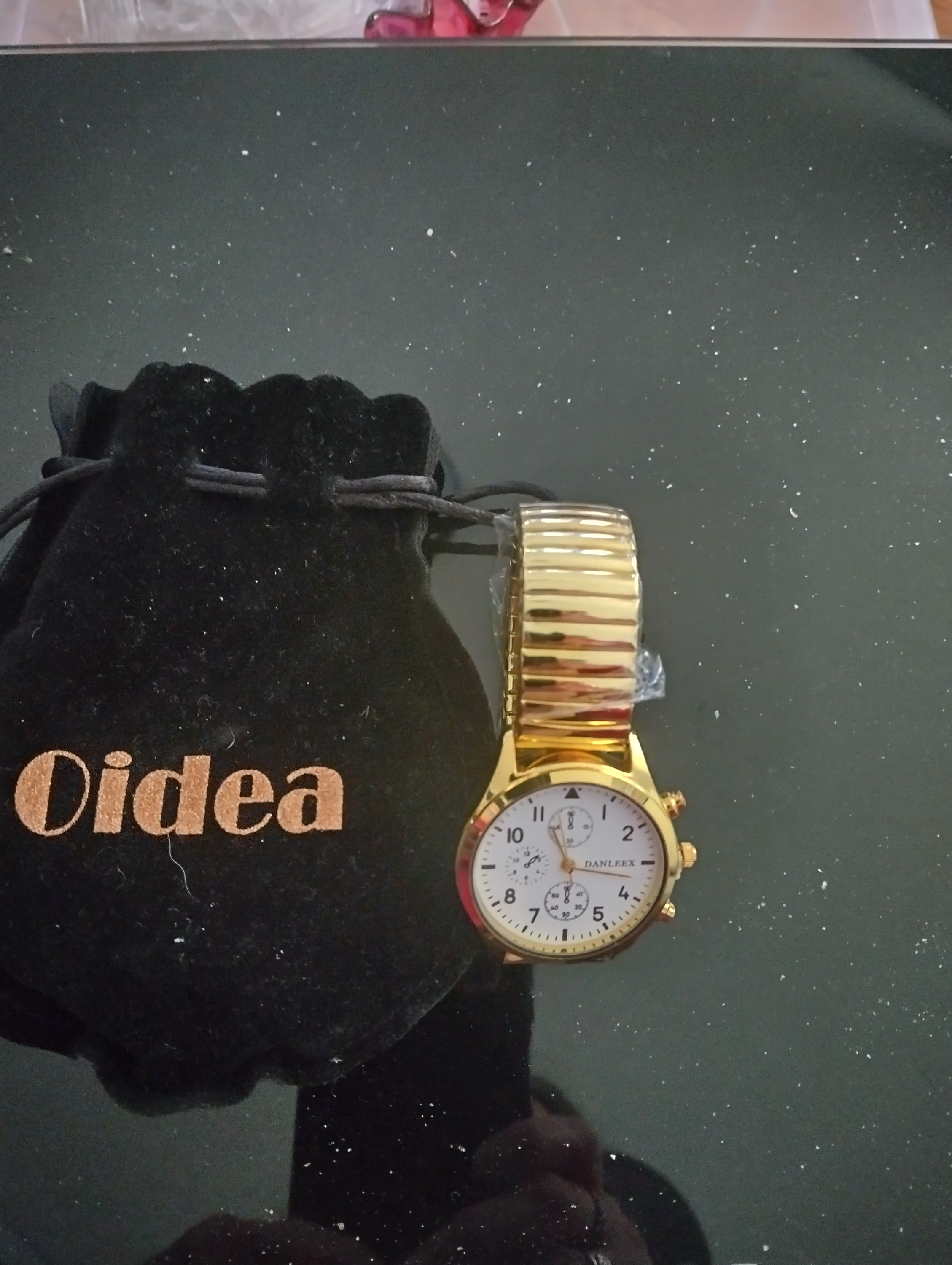 A Danleex gold-toned wristwatch with an pouch