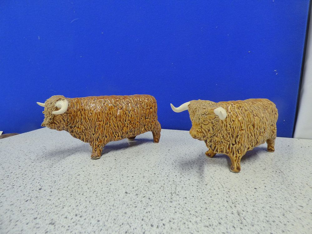 Lot 230: A Pair of Ceramic Brown and White Highland Cow Figurines