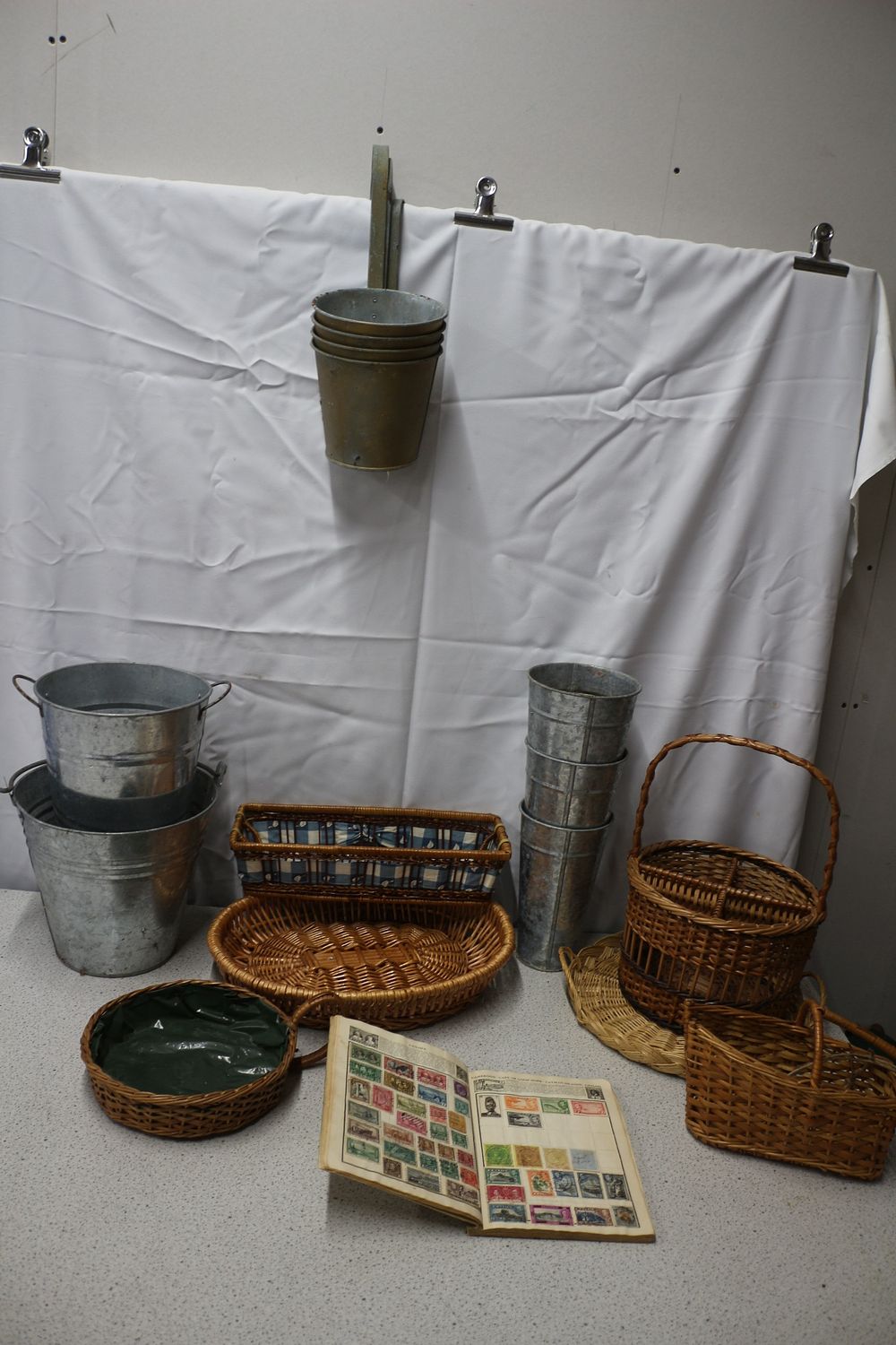 Lot 219: A Collection of Galvanized Buckets, Wicker Baskets, and Stamp Album