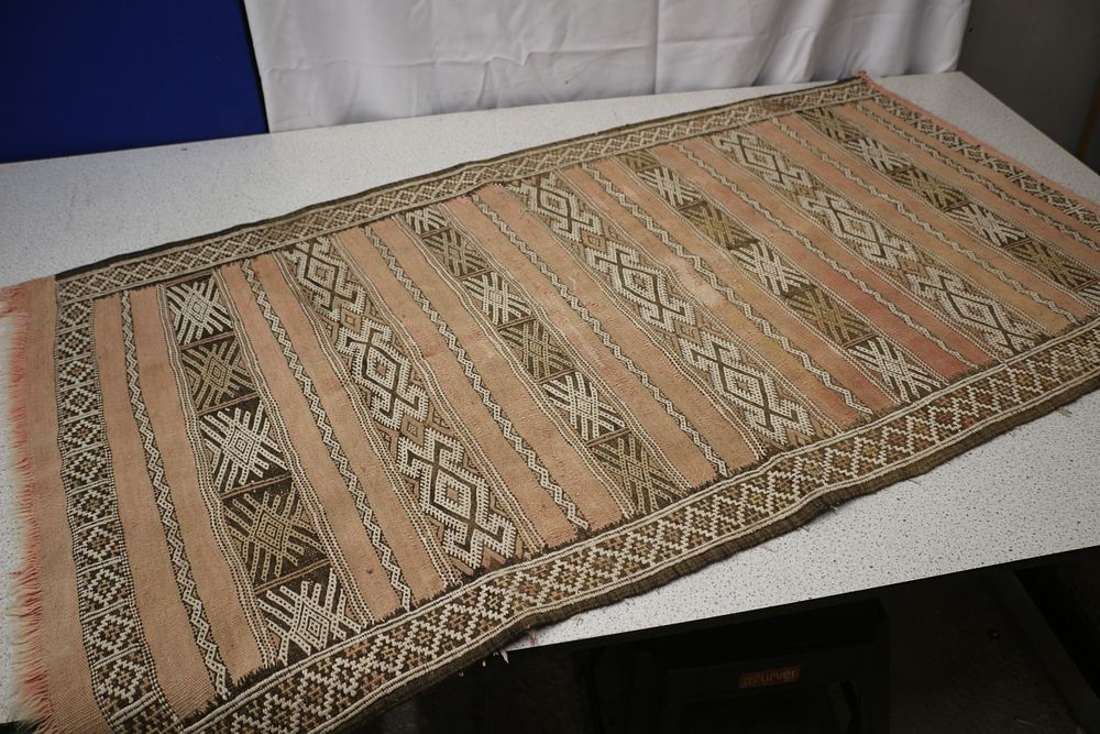 Lot 240: A Faded Pink, Brown, and Cream Striped Geometric Rug