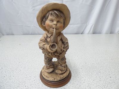 A Vintage Giuseppe Armani Signed Figurine of Boy Smoking a Pipe. A beige, brown, and tan 