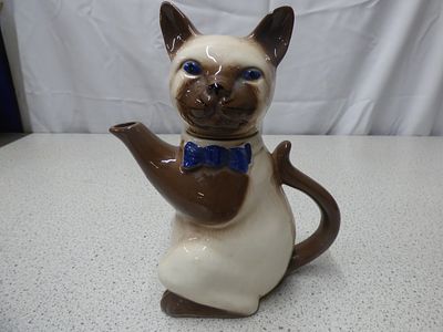 Tony Wood Studio Ceramic Siamese Cat Teapot. A ceramic cat-shaped teapot, primarily cream and 