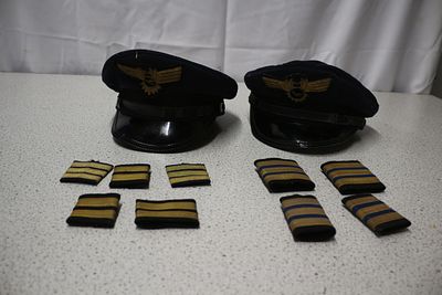 Two Lufthansa Pilot's Caps and a Group of Shoulder Boards. Two dark blue pilot's caps with black 
