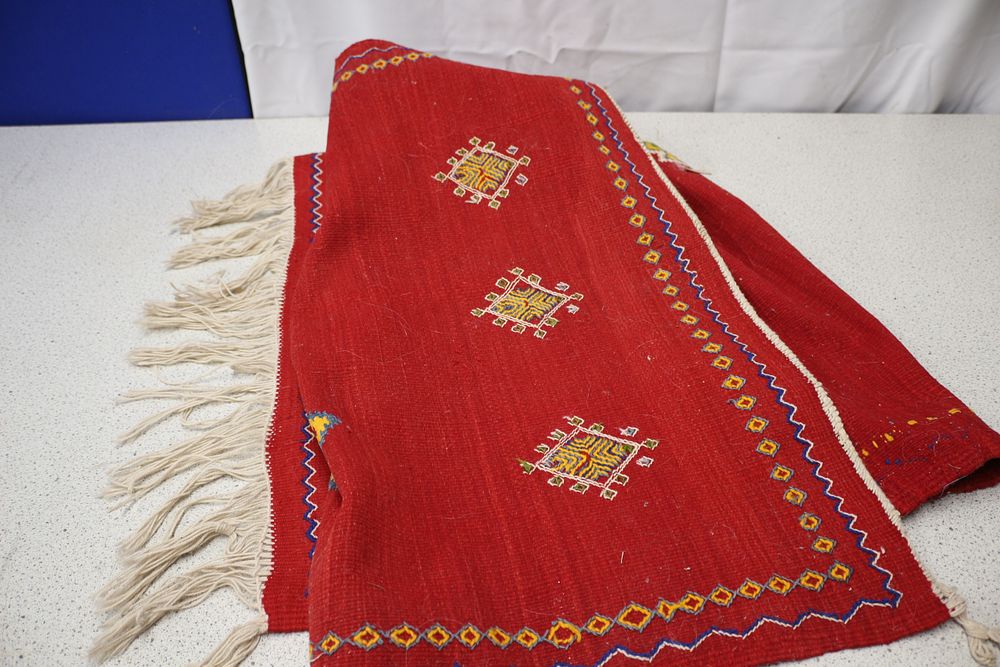 Lot 426: A Large Red Textile Rug with Geometric Patterns
