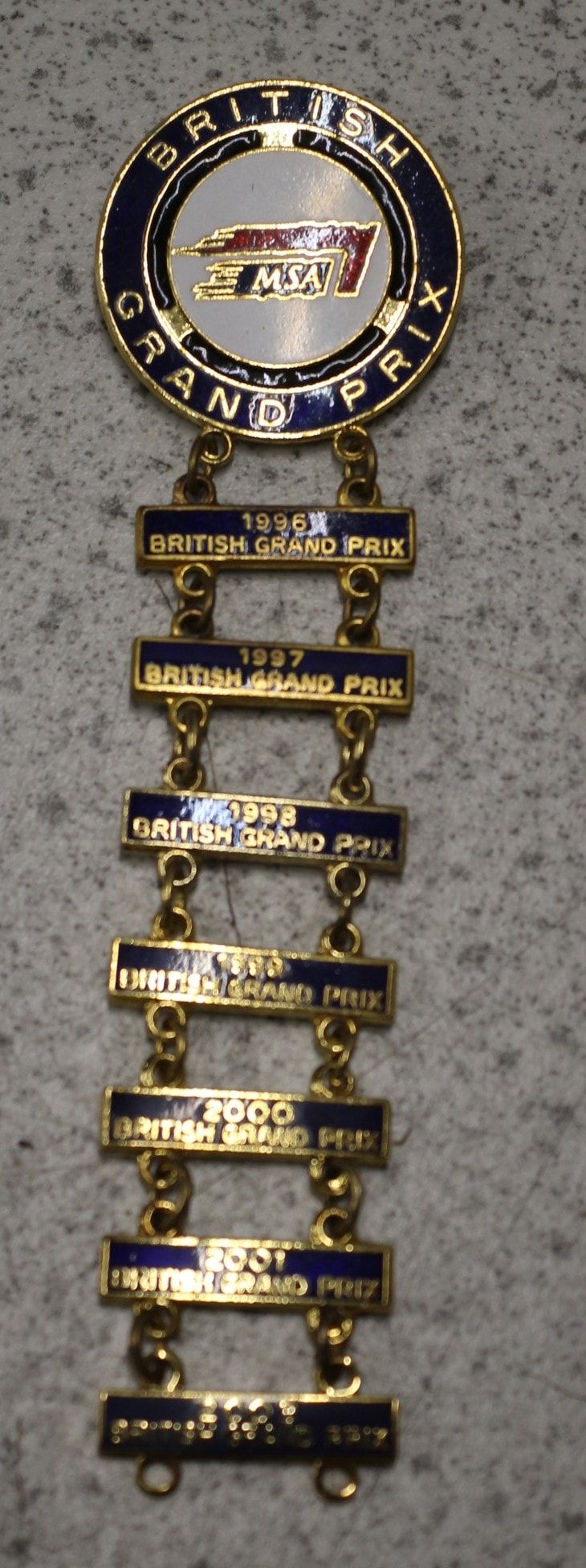 Lot 584: A British Grand Prix Enamelled Badge with Year Bars, 1996-2003