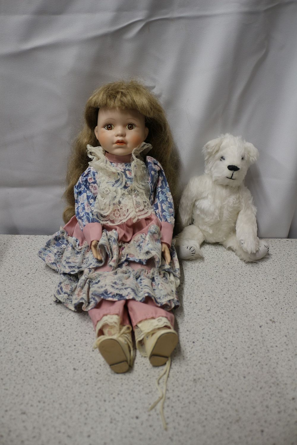 Lot 300: A Pair of Porcelain Doll and Pearl Handmade Teddy Bear