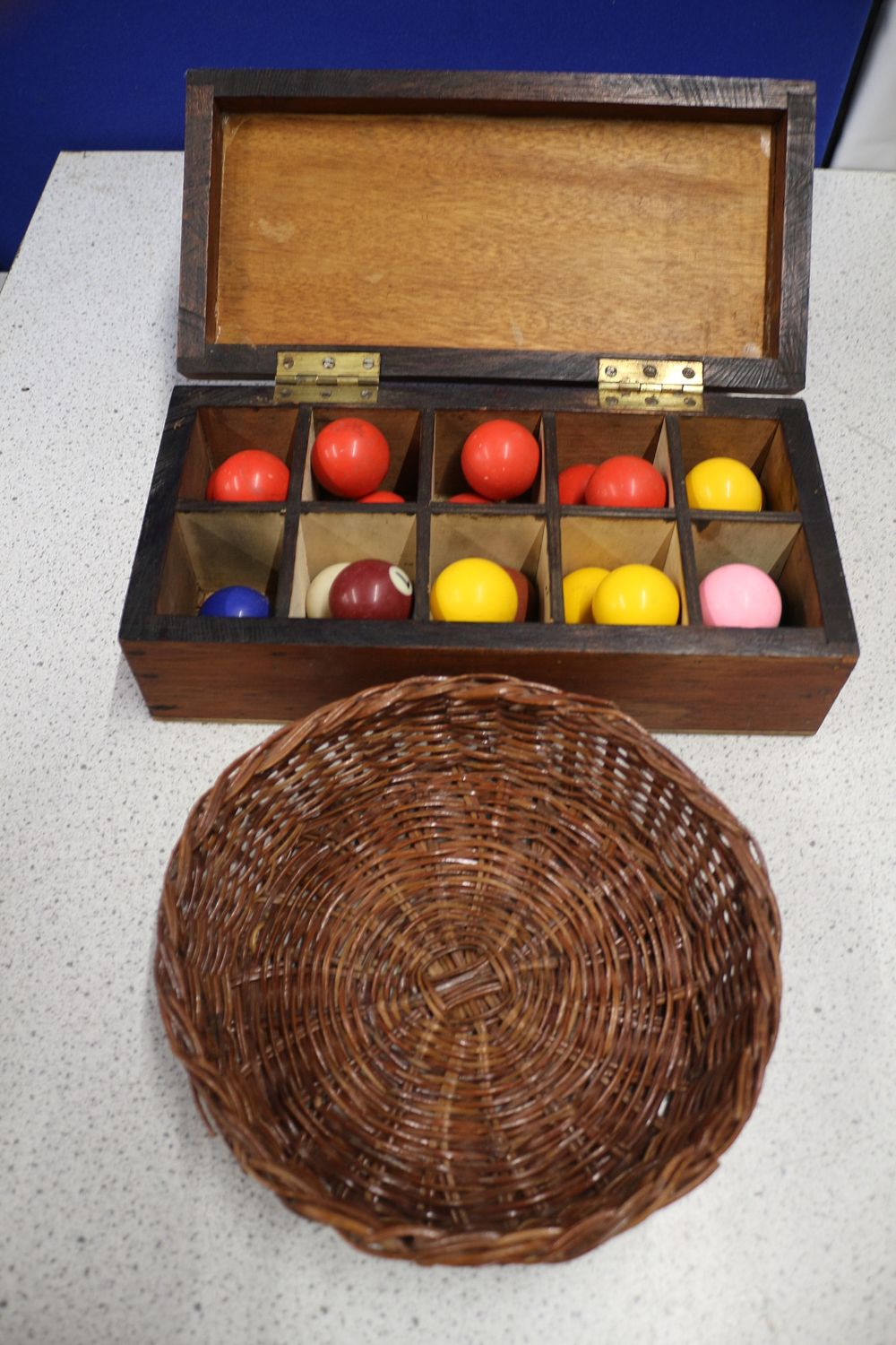 Lot 349: A Collection of Game Balls, Wooden Box, and Wicker Basket